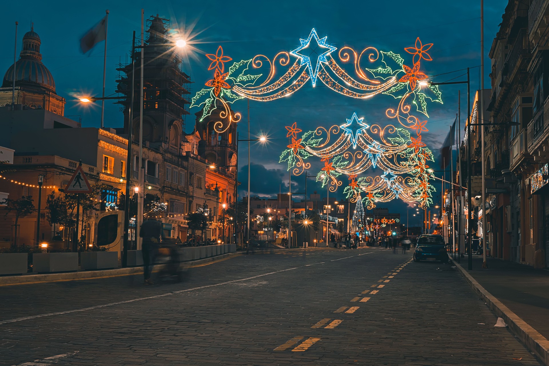 Urban street with Christmas illuminations. Xmas lights and people walking