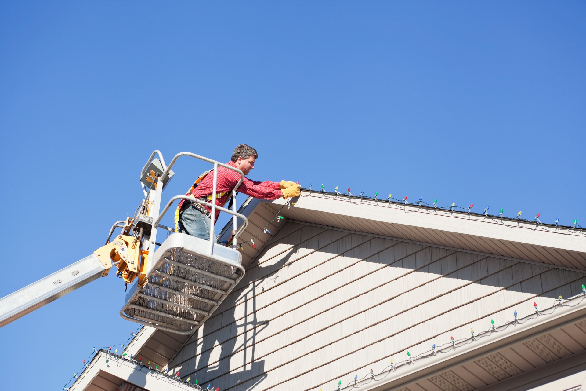 Professional Installing LED Christmas Lights on House Roof